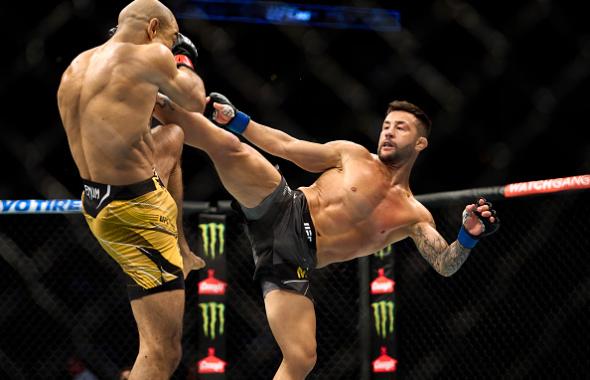 Pedro Munhoz of Brazil kicks Jose Aldo of Brazil in their bantamweight bout during the UFC 265 event at Toyota Center on August 07, 2021 in Houston, Texas. (Photo by Cooper Neill/Zuffa LLC)