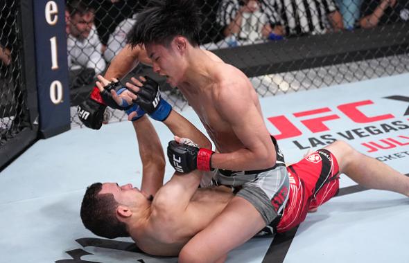 Tatsuro Taira of Japan punches Carlos Candelario in a flyweight fight at UFC APEX on May 14, 2022 in Las Vegas, Nevada. (Photo by Jeff Bottari/Zuffa LLC)